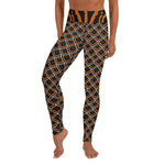A person wearing black, orange, white scalloped pattern yoga leggings inspired by the black and gold slug.