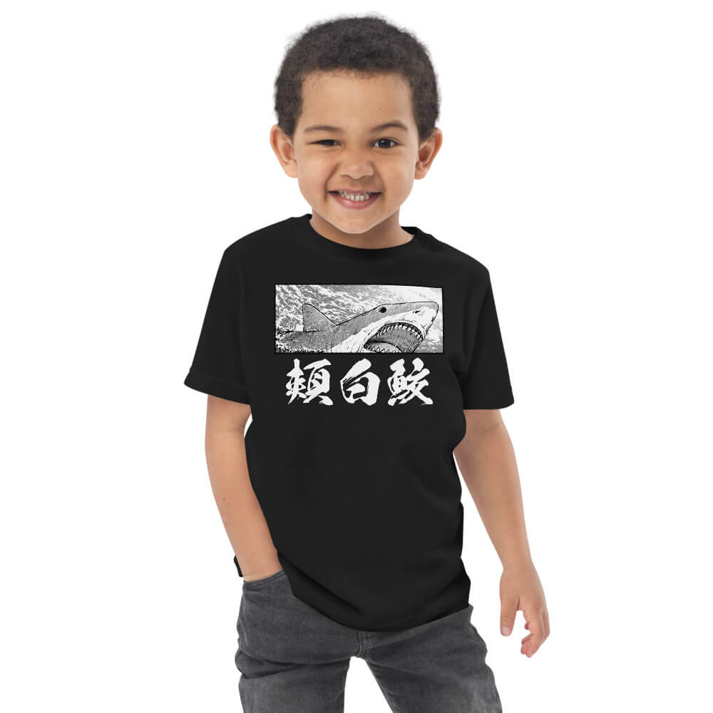 Kid wearing a black color version of the great white shark t-shirt with short sleeves in size 3.