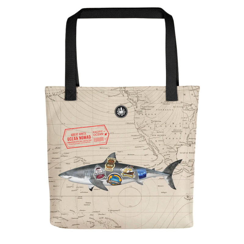 Tote bag with great white ocean nomad swimming across a background map with Thalassas logo at top and black durable straps. 