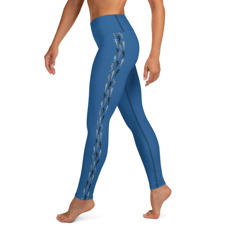 A person in blue ⅞ length leggings with contrasting hammerhead shark pattern running down the outside of each leg.