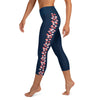 Left side view of woman wearing sporty capri navy blue leggings, coral colored stingray pattern on each side of leg.