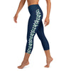 Left side view of a person wearing navy blue capri yoga leggings, seafoam color stingray pattern on side of  legs.
