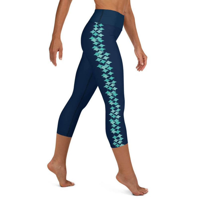 Right side view of person wearing M size navy blue capri leggings with turquoise stingray pattern on left leg.