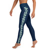 Left side view of a woman wearing navy blue ankle length yoga leggings, seafoam color stingray pattern on each side of leg.