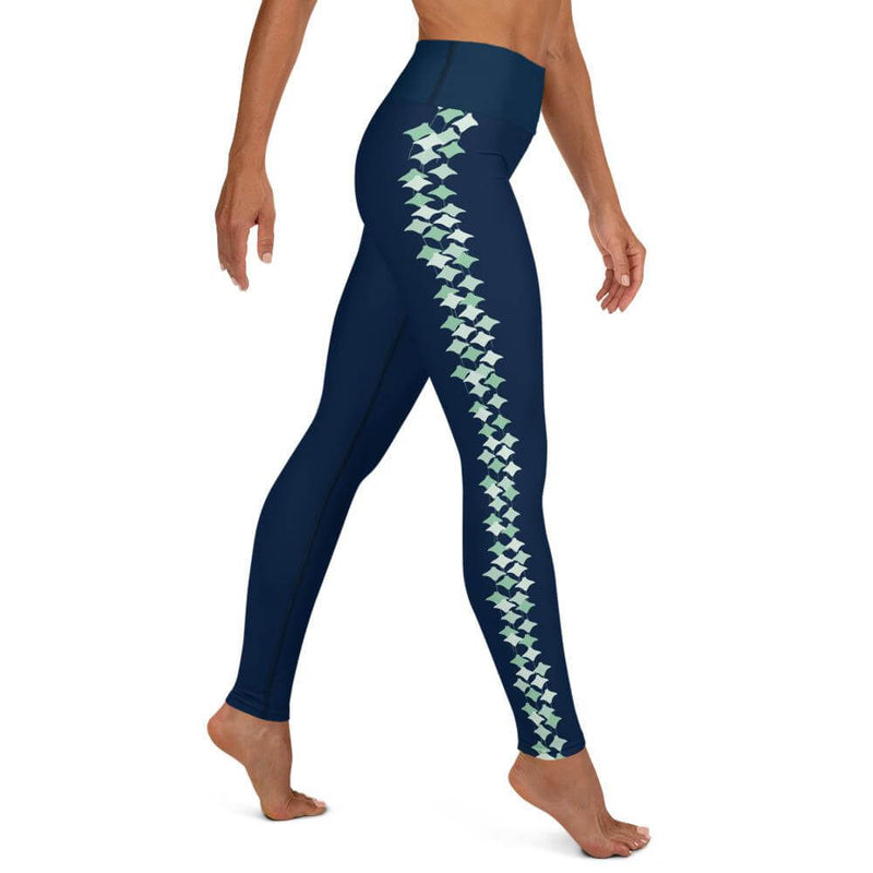 Right side view of a person wearing XL size navy blue leggings with seafoam stingray pattern the side of each leg.