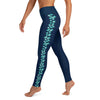 Left side view of woman wearing navy blue leggings with turquoise stingray pattern on the side of each leg.