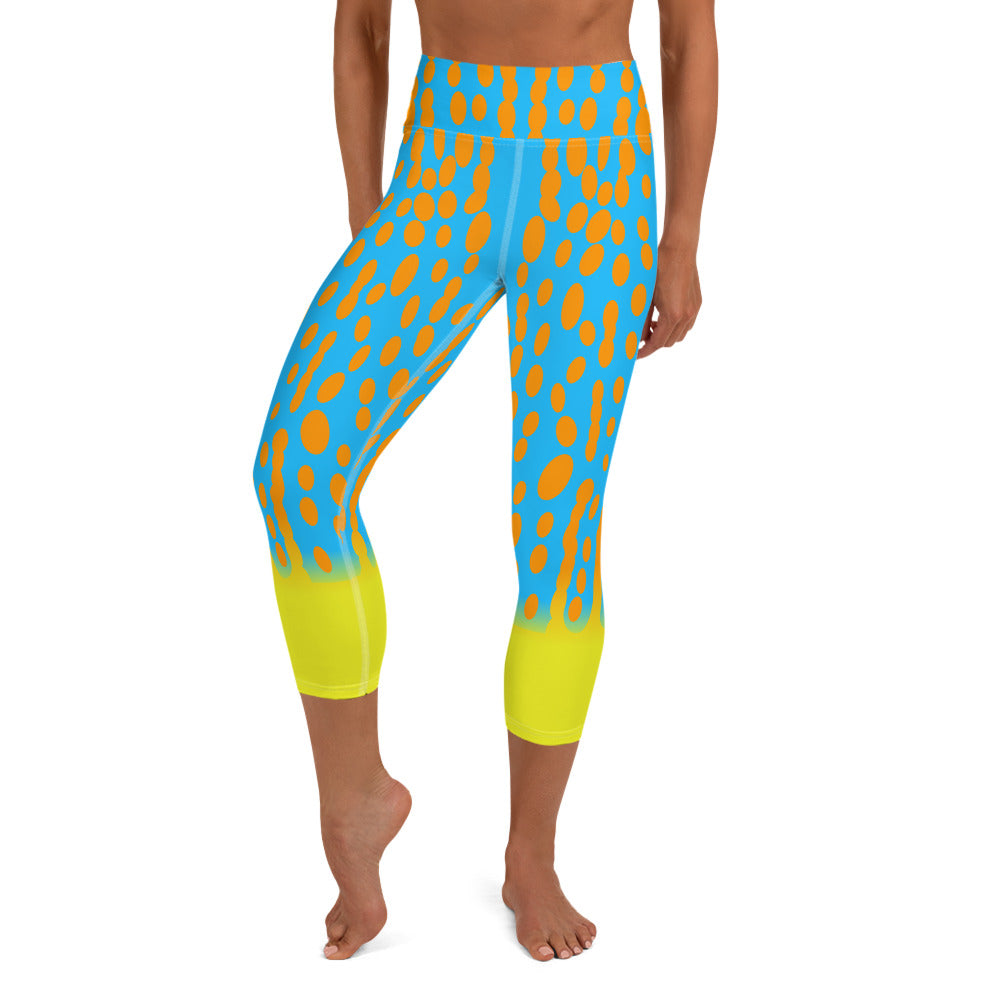 A person wearing turquoise capri yoga leggings, with orange spots, yellow accent at the ankle, inspired by Harlequin Filefish.