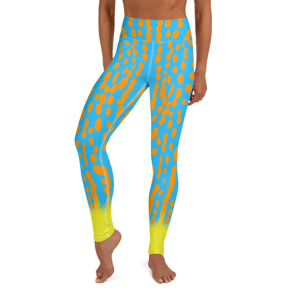 A person wearing turquoise leggings with orange organic spots, yellow accent at ankle inspired by the Harlequin Filefish.