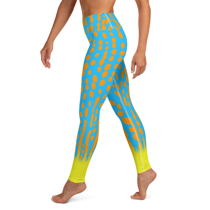 Left side view of model in Harlequin Filefish leggings, showing detail of turquoise, orange and yellow pattern.