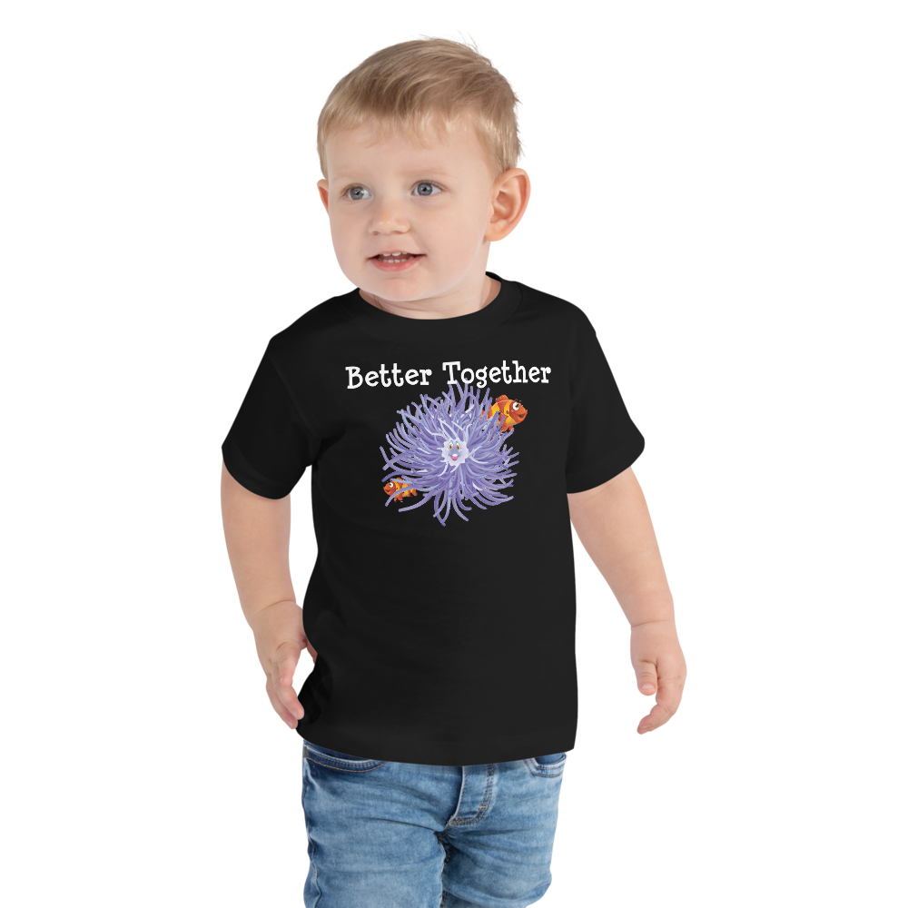 Toddler wearing a black short sleeve t-shirt with clownfish and anemone friendship design in size 2T. 