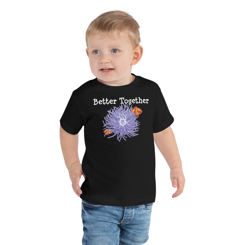 Toddler wearing a black short sleeve t-shirt with clownfish and anemone friendship design in size 2T. 